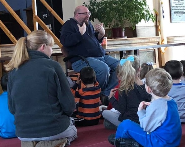 Picture of Big Ryan telling stories to children