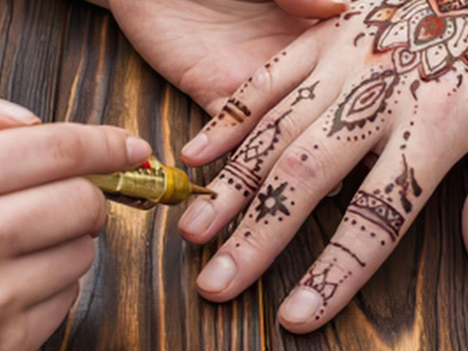 Picture of a henna tattoo being applied to a hand